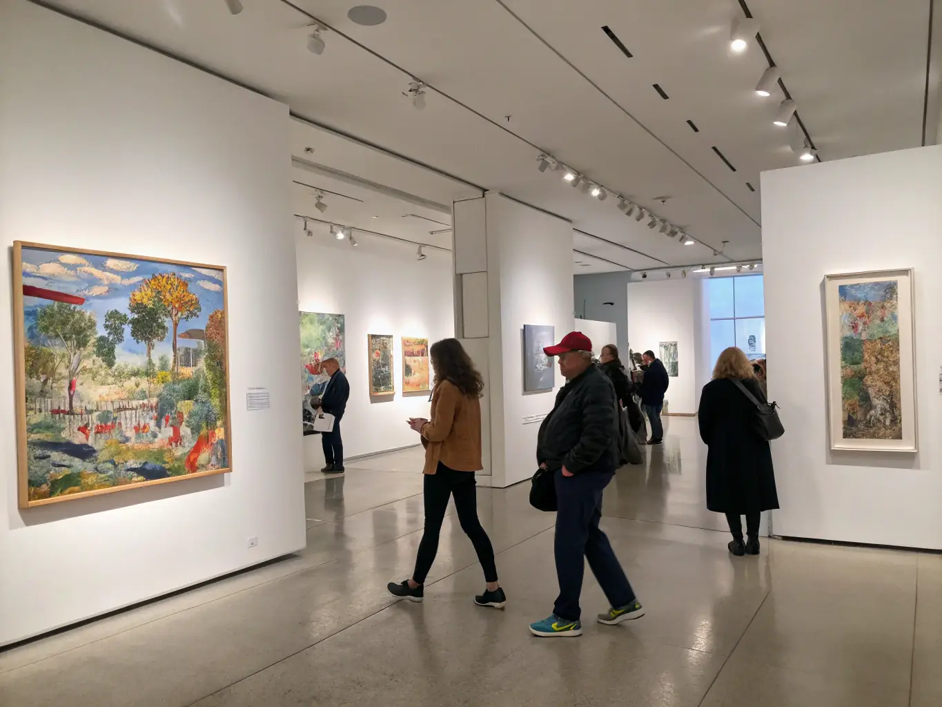 A photograph of an art exhibition at LE LEZ'ART, featuring a variety of artworks on display and visitors admiring the pieces. The gallery space is well-lit and inviting, creating a welcoming atmosphere for art lovers.